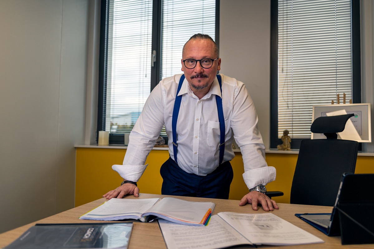 Sebastian Dutkiewicz przy biurku, otoczony materiałami i dokumentami